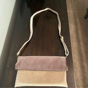 Anthropologie fold over crossbody bag with removable strap.